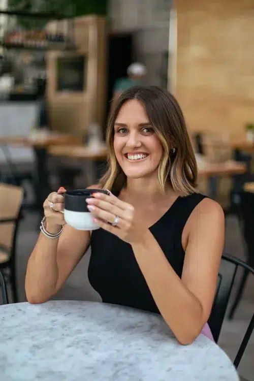 Kelly smiling with a coffee