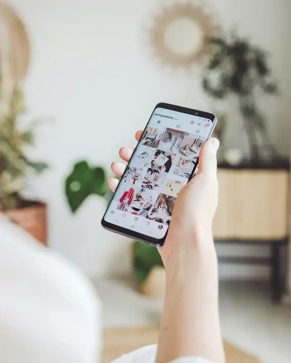 A hand holding a phone open on Instagram